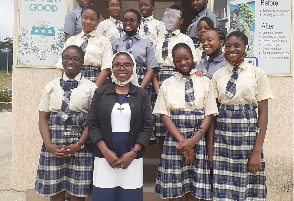 Sr. Teresa Anyabuike, a member of the African Faith and Justice Network, bottom middle, poses with students after a seminar about child abuse and human trafficking in Abuja, Nigeria. Sr. Eucharia Madueke writes that GSR coverage has enhanced the network's credibility and inspired sisters within and outside Africa. (CNS/Courtesy of Sr. Eucharia Madueke)