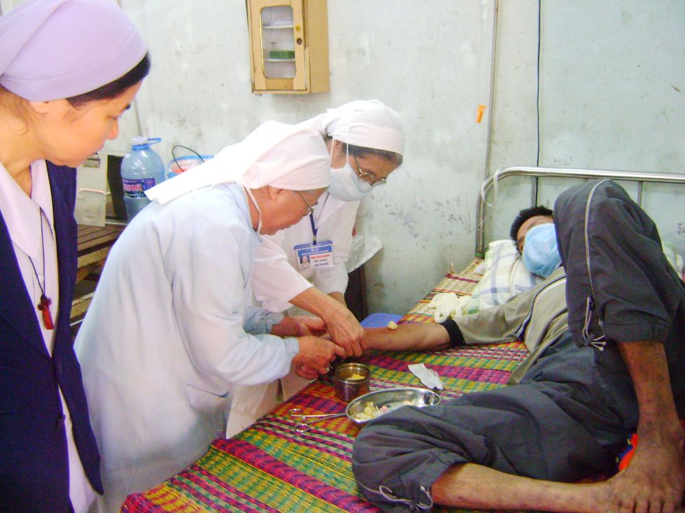 Sr. Josephine Huynh Thi Ly (center) and another nun inject a patient at the Central Hospital in Hue in April 2023. 
