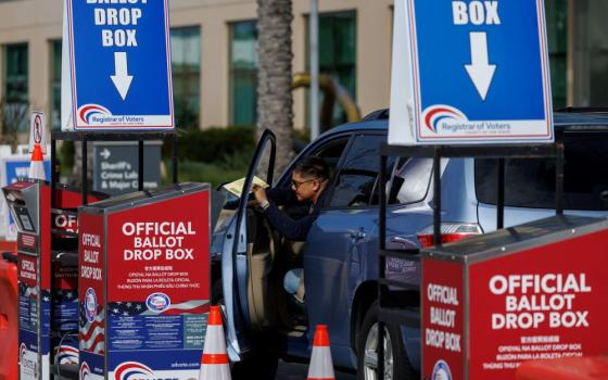 A voter drops a ballot paper into a drop box from his vehicle in San Diego during the Super Tuesday primary election March 5. 