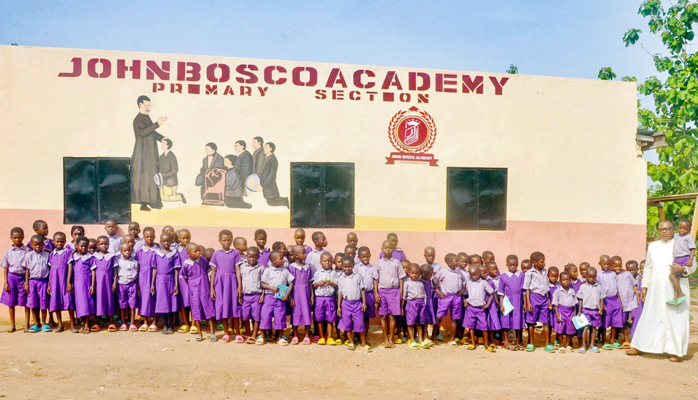 Elementary school pupils of John Bosco Academy, formerly St. Peter's Catholic School, in Ogoja, Cross River State, Nigeria, pose for a photo with Fr. Peter Abue, founder of the Children of Rural Africa initiative. (Valentine Benjamin)